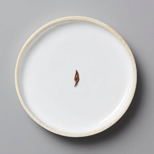Anshun Jin Jun Mei black tea bud on white ceramic plate with beige rim against gray background