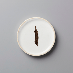 PANLAN 105 yancha oolong tea leaf displayed on white ceramic plate against grey background
