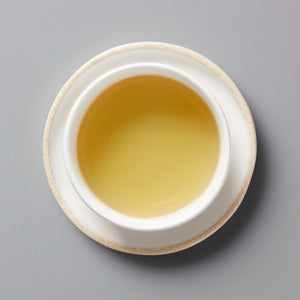 Panlan Bei Dou unroasted oolong tea in white ceramic cup, showing golden amber liquid viewed from above