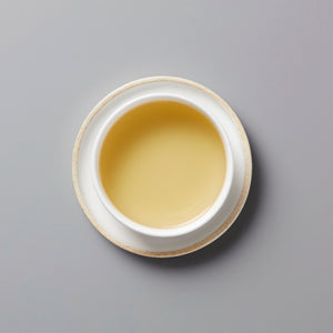 Golden Lins Big Leaf dancong oolong tea in white ceramic cup on gray background