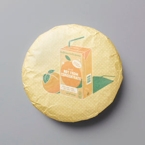 2020 Not From Concentrate white tea cake with orange juice box design on light yellow wrapper