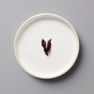 ZI RAN RED black tea leaves on a minimalist white ceramic plate with raised rim, showcasing traditional Tongmu tea