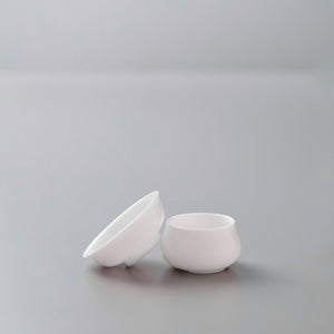 White porcelain filter and stand set for tea brewing, featuring conical strainer and round drip catch base