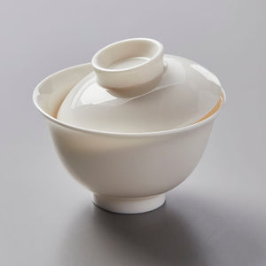 Gaiwan Hugo traditional white porcelain lidded tea bowl with wide base and curved rim against gray background