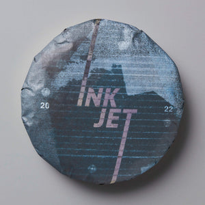 Ink Jet shou puer tea cake with blue-tinted wrapper featuring minimalist diagonal text design and 2022 marking