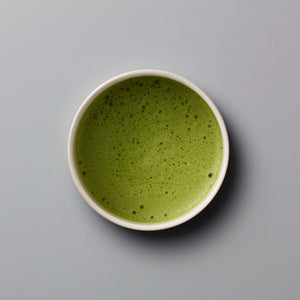 Matcha Sonogi ceremonial grade tea in white ceramic bowl with frothy bright green surface and fine bubbles