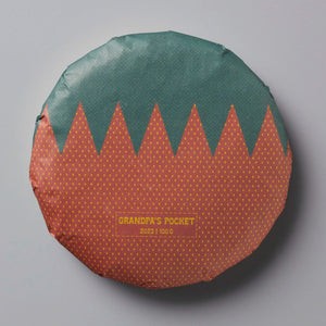 Grandpas Pocket huangpian puer tea cake with green and orange polka dot pattern and zigzag design