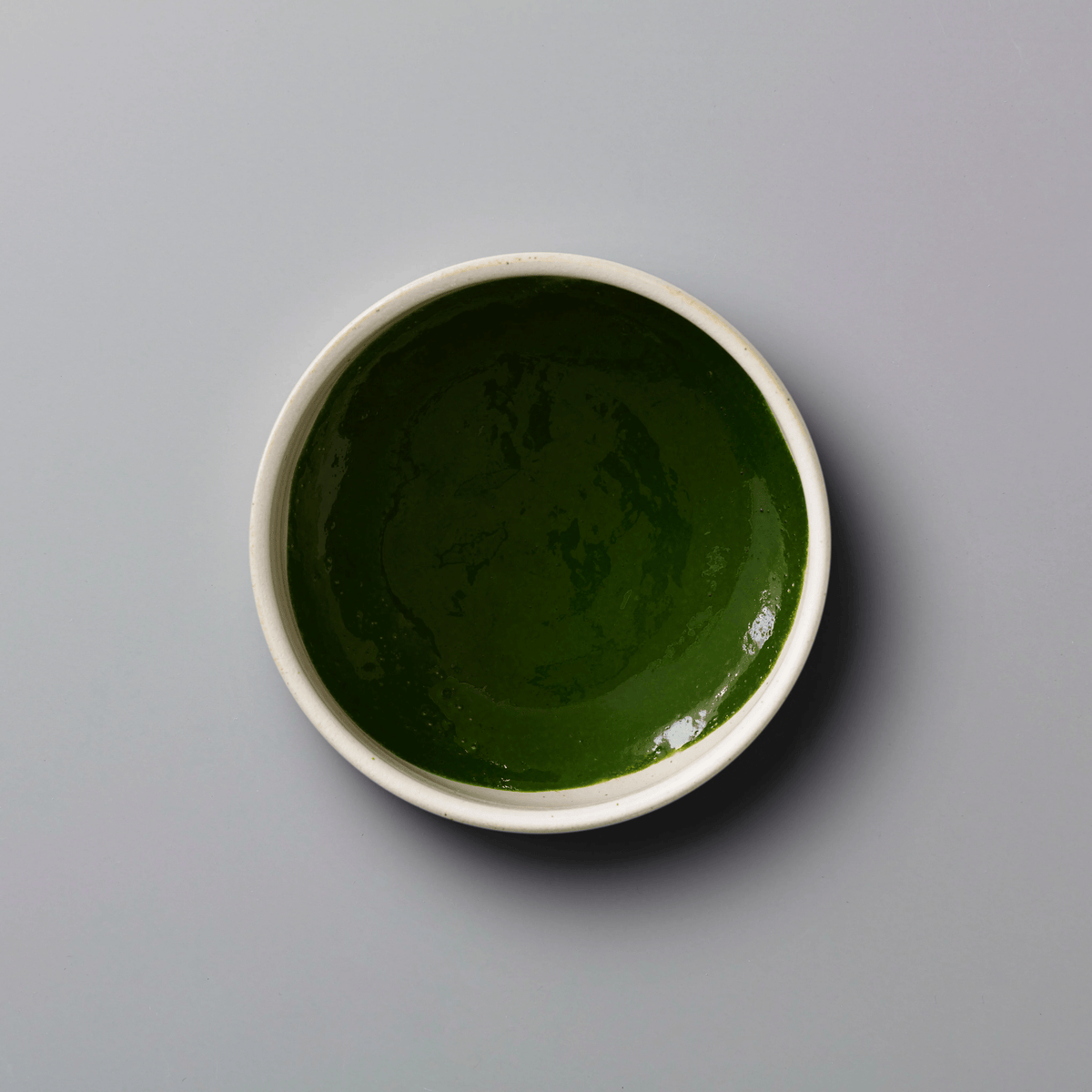 Matcha Kame ceremonial grade green tea powder in white ceramic bowl showing vibrant emerald color and smooth texture