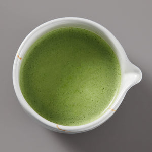Matcha Bowl KUMO filled with vibrant green matcha tea in white ceramic bowl with gold accents, viewed from above