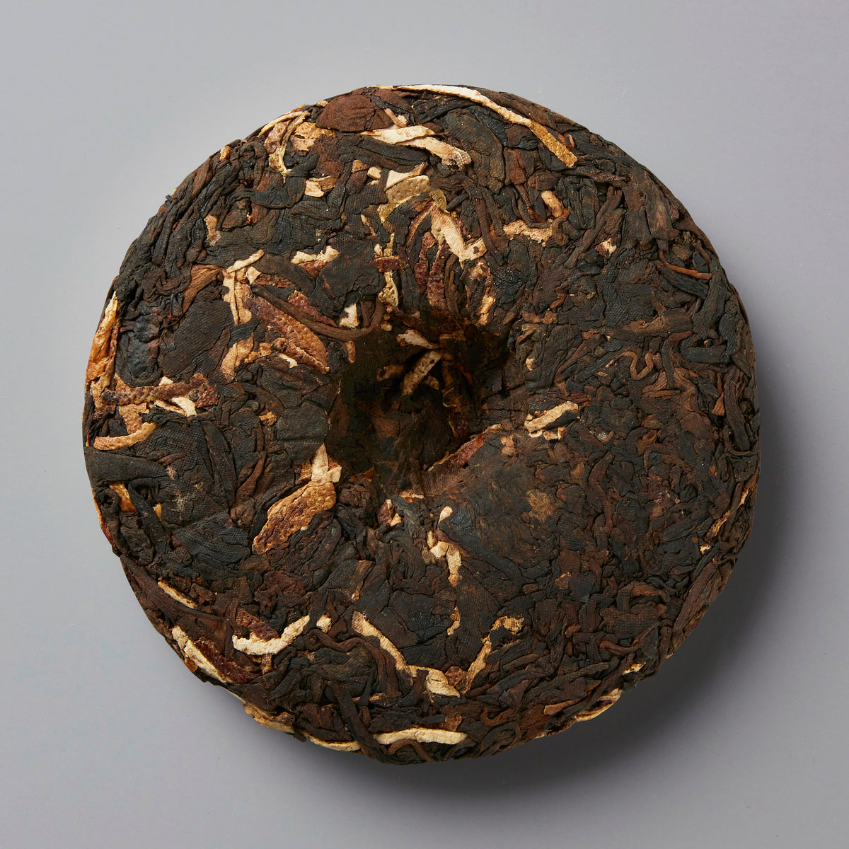 YARD BEER chenpi shou puer tea cake with dark leaves and orange peel flecks pressed into traditional disc shape