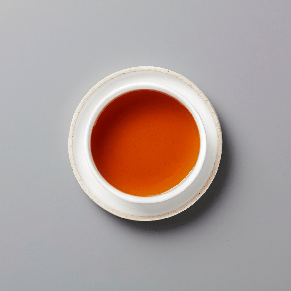 PANLAN 105 yancha oolong tea in white ceramic cup showing rich amber-colored liquor on grey background