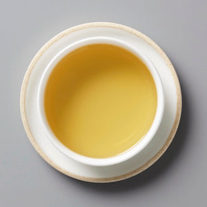 BOUQUET tisane blend in white ceramic cup showing golden-hued infusion viewed from above