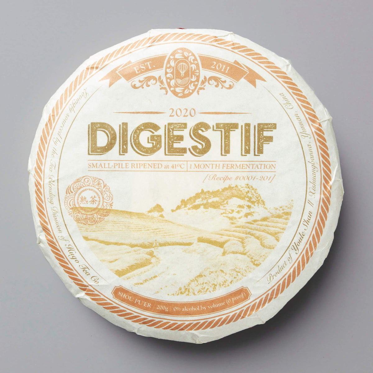 2020 Digestif shou puer tea cake with golden mountain landscape design on white wrapper