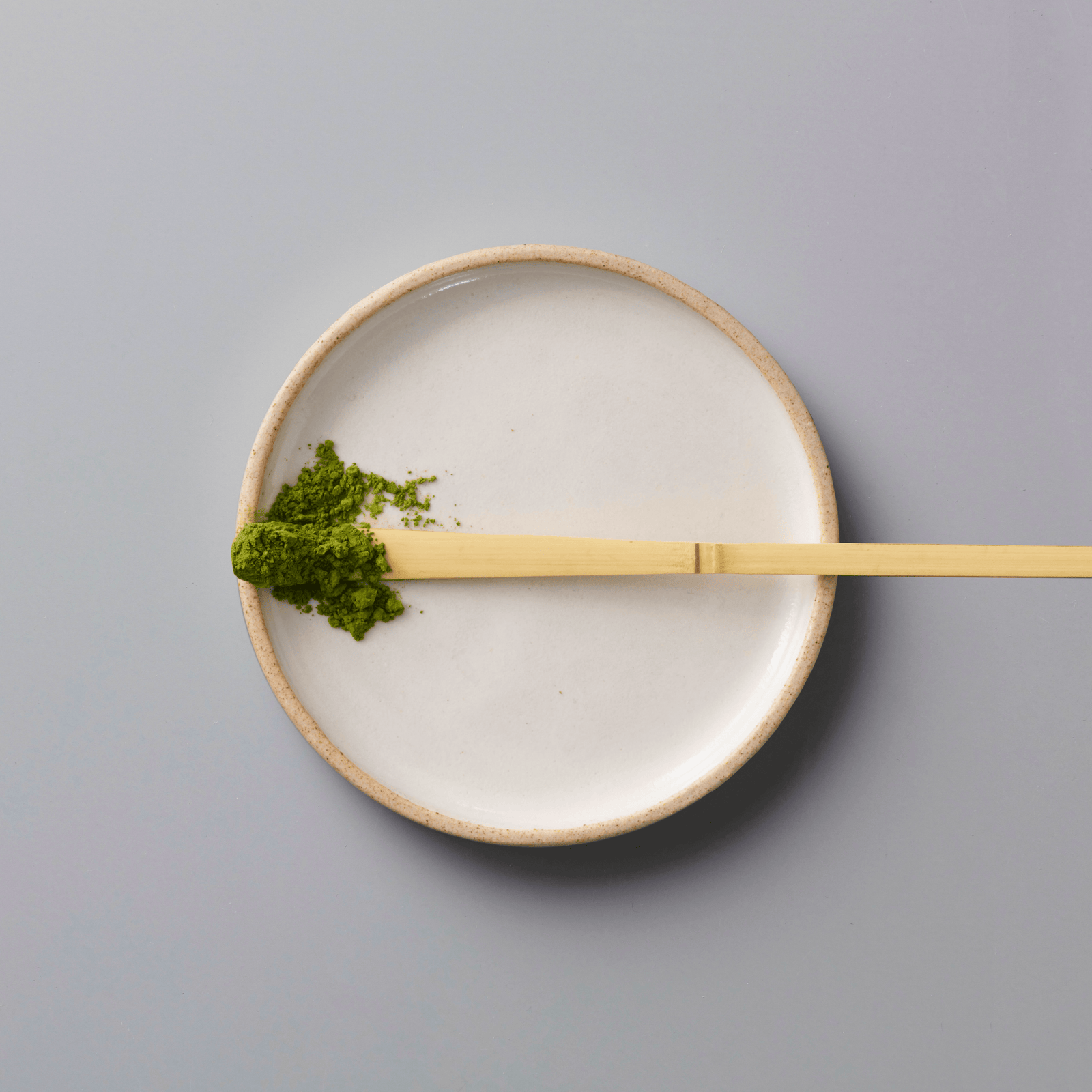Matcha Sonogi ceremonial grade with bamboo whisk and vibrant green tea powder on minimalist ceramic plate